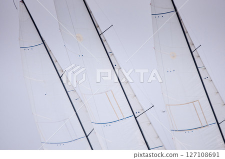 multiple sails at the sailing regatta in the Gulf of Finland at cloudy weather, hot race of several yachts, nobody 127108691