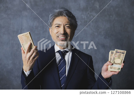 微笑的高級商人拿著一疊鈔票 127108866