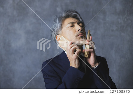 微笑的高級商人拿著一疊鈔票 微笑的高級商人拿著一疊鈔票 127108870