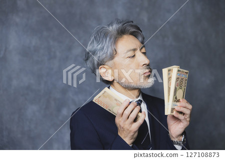 微笑的高級商人拿著一疊鈔票 127108873