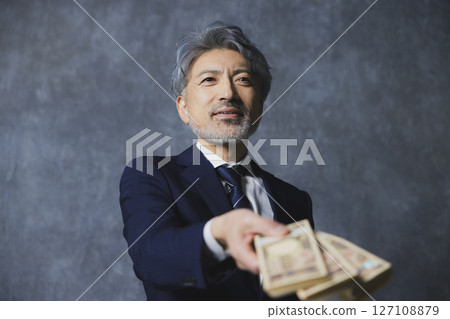微笑的高級商人拿著一疊鈔票 127108879