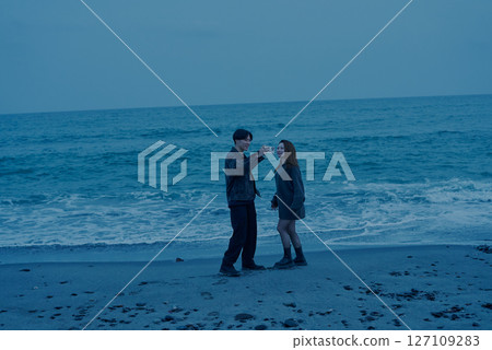 日落時分,年輕男女在海灘上散步 日落時分,年輕男女在海灘上散步 127109283
