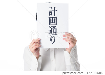 A person holding a piece of paper that says "As planned" 127109606
