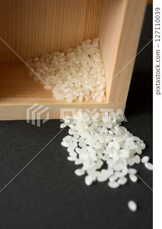 木製量杯中灑出了一點米 127110039