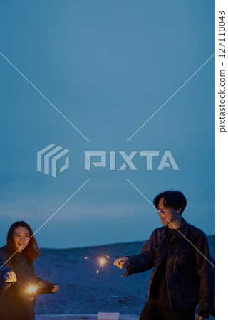 夜晚，年輕男女在海灘上玩手持煙火 127110043