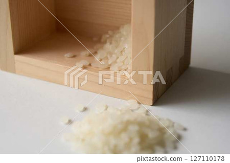 木製量杯中灑出了一點米 127110178