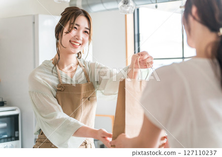 在咖啡館和餐廳向顧客分發外帶產品的女性咖啡館的容量 127110237