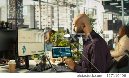 Jolly bookkeeper at work happy after finally finishing reading and verifying business documents. Cheerful employee pleased after finishing analyzing company information records, camera B 127110406