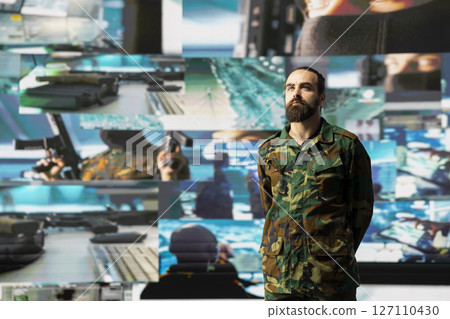 Young army officer working in a virtual war zone with digital tech and satellite data, using threat detection tools for national safety. Modern military strategy to ensure control in a mission. 127110430