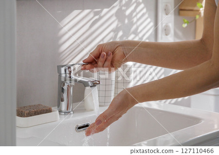 Woman washing female hands close up in washbasin with clean running water.  127110466