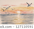 The sun setting on the horizon and seagulls flying 127110591