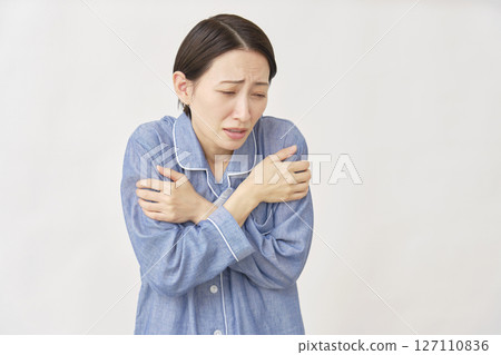 Woman in pajamas, cold, white background 127110836