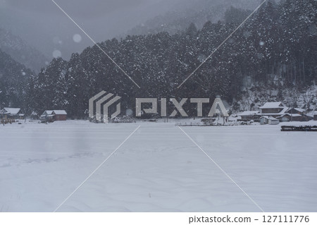 這張照片是在京都南丹市美山町被雪覆蓋的茅草屋頂村拍攝的。 127111776