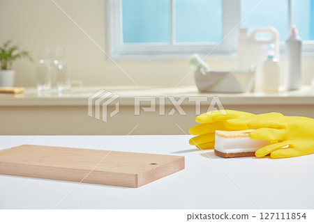 Minimalist countertop with wine glasses, a pink cloth, and a translucent spray bottle, lit by soft morning sunlight through the window. Minimalist countertop with wine glasses, a pink cloth, and a translucent spray bottle, lit by soft morning sunlight through the window. 127111854