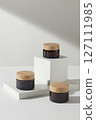 Cosmetics advertising scene with minimalist concept. Three cosmetic jars no label displayed on white podium on a white background. Mock up packaging, cosmetics design 127111985