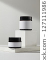 Blank minimal design concept. Two amber cosmetic jars unlabeled displayed on white podiums on a white background. Front view, space for add your label 127111986