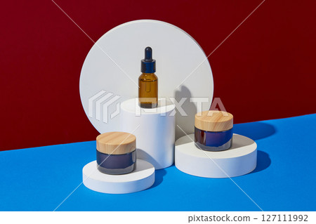 Minimalist creative background for cosmetics or products presentation with space for design label. Three cosmetic mockup bottles decorated with white geometries podiums on color background 127111992
