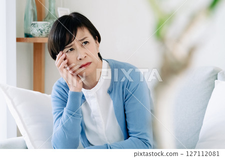 Middle-aged woman feeling depressed in the living room 127112081