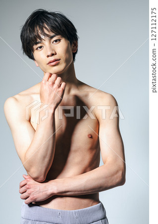 赤裸上身的年輕男子用手托著下巴 127112175