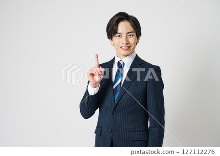 一個穿西裝的年輕人指著 127112276