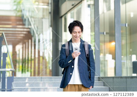 使用智慧型手機的商人。拍攝合作:SKY Perfect Tokyo Media Center 使用智慧型手機的商人。拍攝合作:SKY Perfect Tokyo Media Center 127112389