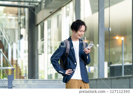 使用智慧型手機的商人。拍攝合作：SKY Perfect Tokyo Media Center 127112393