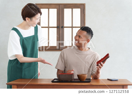 Foreign tourists eating Japanese food and restaurant staff 127112558