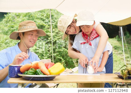 Family preparing vegetables at a campsite Family preparing vegetables at a campsite 127112948