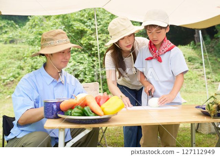 Elementary school boy learning how to cut vegetables 127112949