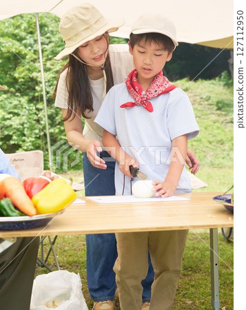 Elementary school boy learning how to cut vegetables Elementary school boy learning how to cut vegetables 127112950