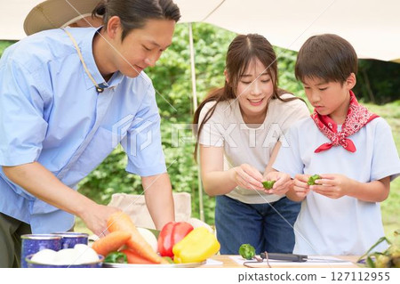 Elementary school boy learning to cook at a campsite Elementary school boy learning to cook at a campsite 127112955