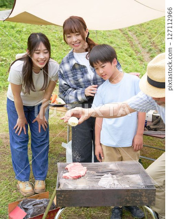 A family enjoying intergenerational interaction at a barbecue A family enjoying intergenerational interaction at a barbecue 127112966