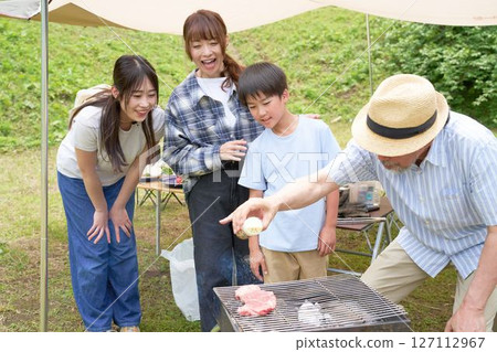 A family enjoying intergenerational interaction at a barbecue 127112967