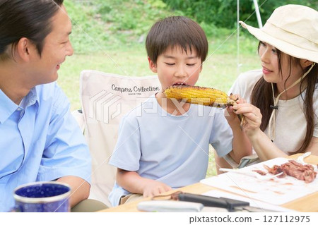 Boy eating roasted corn Boy eating roasted corn 127112975