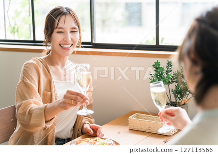 Women toasting with champagne at a lunch party (mom friends, friends, relaxing) 127113566