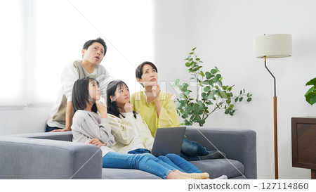 小學姊妹和她們的家人一邊看著筆記型電腦一邊擔心 127114860