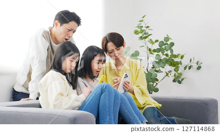 小學女孩的家人看著智慧型手機，表情憂慮 127114868