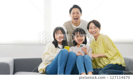 A family of elementary school girls smiling and holding smartphones A family of elementary school girls smiling and holding smartphones 127114870