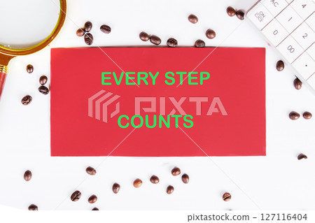Concept text EVERY STEP COUNTS written on red paper on a work surface surrounded by coffee beans and a magnifying glass 127116404