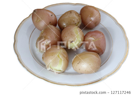 Boiled unpeeled potatoes on a porcelain plate. 127117246