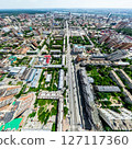 Aerial city view with crossroads and roads, houses, buildings, parks and parking lots. Sunny summer panoramic image 127117360