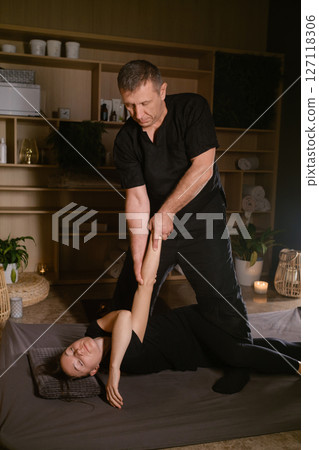 Professional masseur gives Girl Thai massage in massage parlor. Traditional Asian stretching therapy Professional masseur gives Girl Thai massage in massage parlor. Traditional Asian stretching therapy 127118306