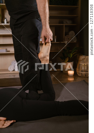 Girl in Thai massage session from therapist in massage room . Traditional Asian stretching therapy Girl in Thai massage session from therapist in massage room . Traditional Asian stretching therapy 127118308