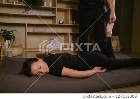 Girl in Thai massage session from therapist in massage room . Traditional Asian stretching therapy 127118309