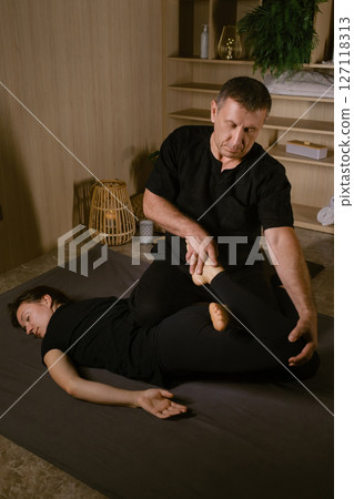 Professional therapist gives back massage for pain relief at spa. Thai massage with a masseur in a spa salon 127118313