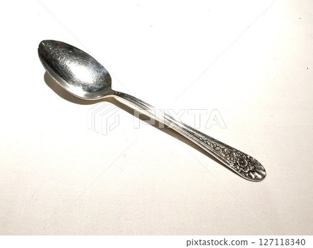 Silver spoon on a white table Silver spoon on a white table 127118340