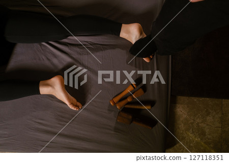 A man gives a relaxing Thai foot massage with a Tok-Sen massage kit at a beauty spa. Body care A man gives a relaxing Thai foot massage with a Tok-Sen massage kit at a beauty spa. Body care 127118351