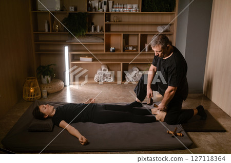 Massage therapist performs a relaxing Thai foot massage using a Tok-Sen massage set at the spa. Body care Massage therapist performs a relaxing Thai foot massage using a Tok-Sen massage set at the spa. Body care 127118364