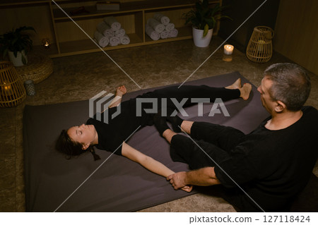 Professional masseur gives Girl Thai massage in massage parlor. Traditional Asian stretching therapy Professional masseur gives Girl Thai massage in massage parlor. Traditional Asian stretching therapy 127118424