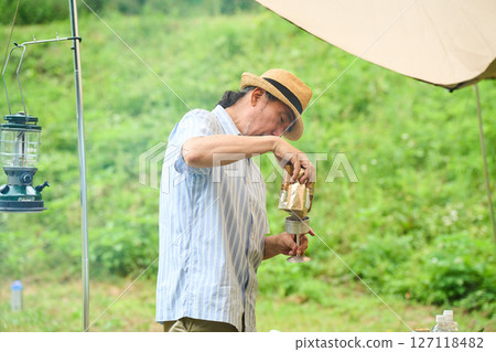 Senior making coffee Camping image Camping Outdoor Barbecue BBQ 127118482